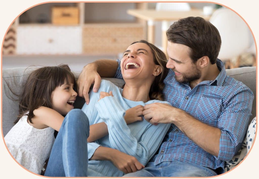 family luaghing  on a couch in burnsville mn