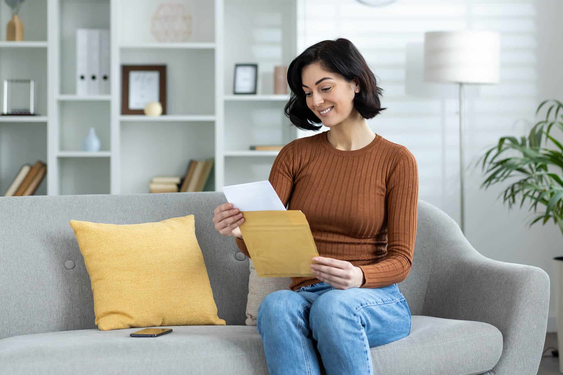 Woman looking at mail no longer in dental pain in Bursville MN