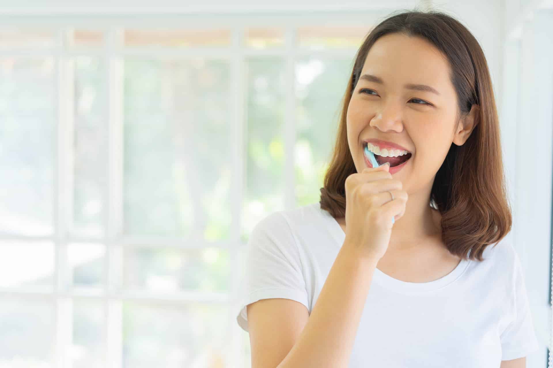 woman in Burnsville MN cleaning her teeth